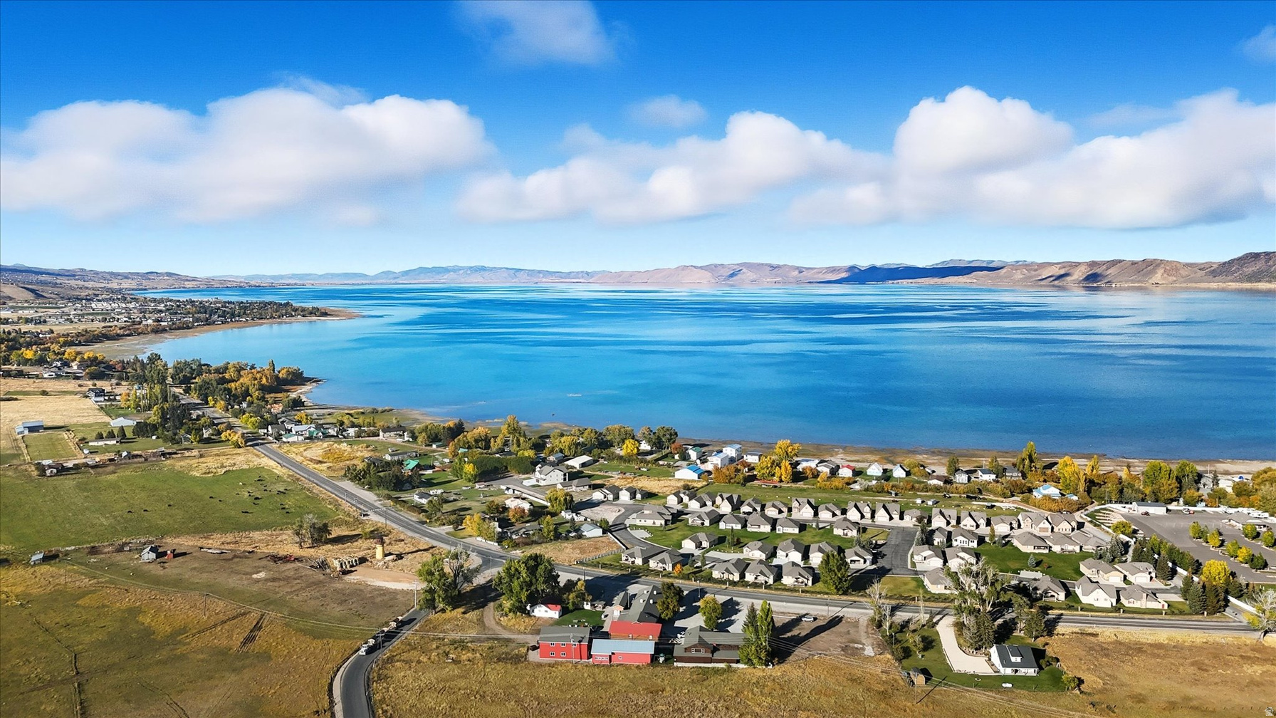 Aerial panorama of Bear Lake from above Garden City Utah with cottonwood-lined shoreline and turquoise water
